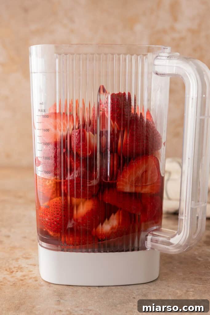Fresh, hulled strawberries in a blender, ready to be pureed.