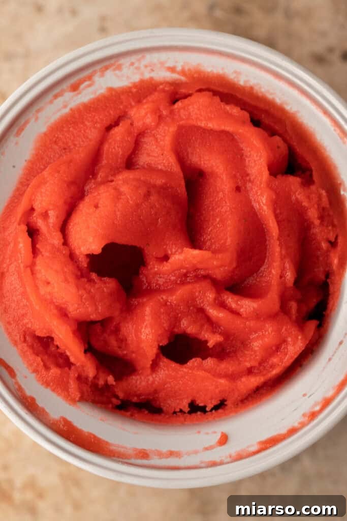 Blended strawberry puree poured into a bowl for chilling.