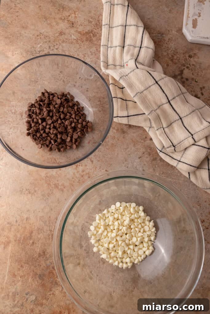 Separate bowls of melted milk chocolate and white chocolate chips, ready for coating.