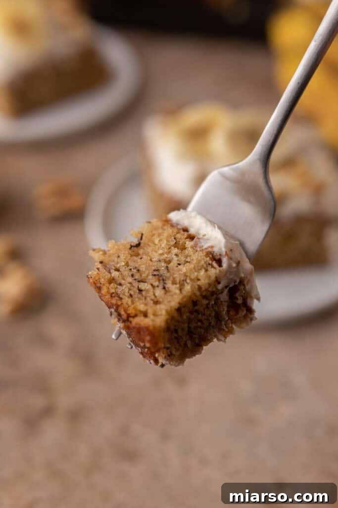 Simply Irresistible Banana Cake 14 A close-up of a piece of banana cake on a fork, showing the fluffy cake and creamy frosting