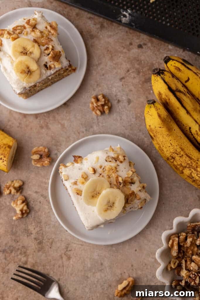 Simply Irresistible Banana Cake 15 An overhead shot of two plates, each holding a slice of banana cake