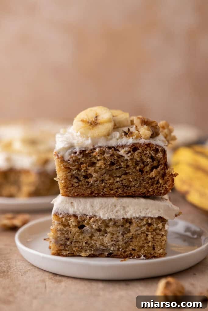 Simply Irresistible Banana Cake 16 Two generous slices of banana cake, stacked on top of each other, displaying the rich frosting