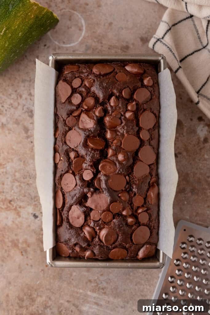 Decadent Double Chocolate Zucchini Loaf 10 Freshly baked Double Chocolate Zucchini Bread in the loaf pan, showing a cracked top