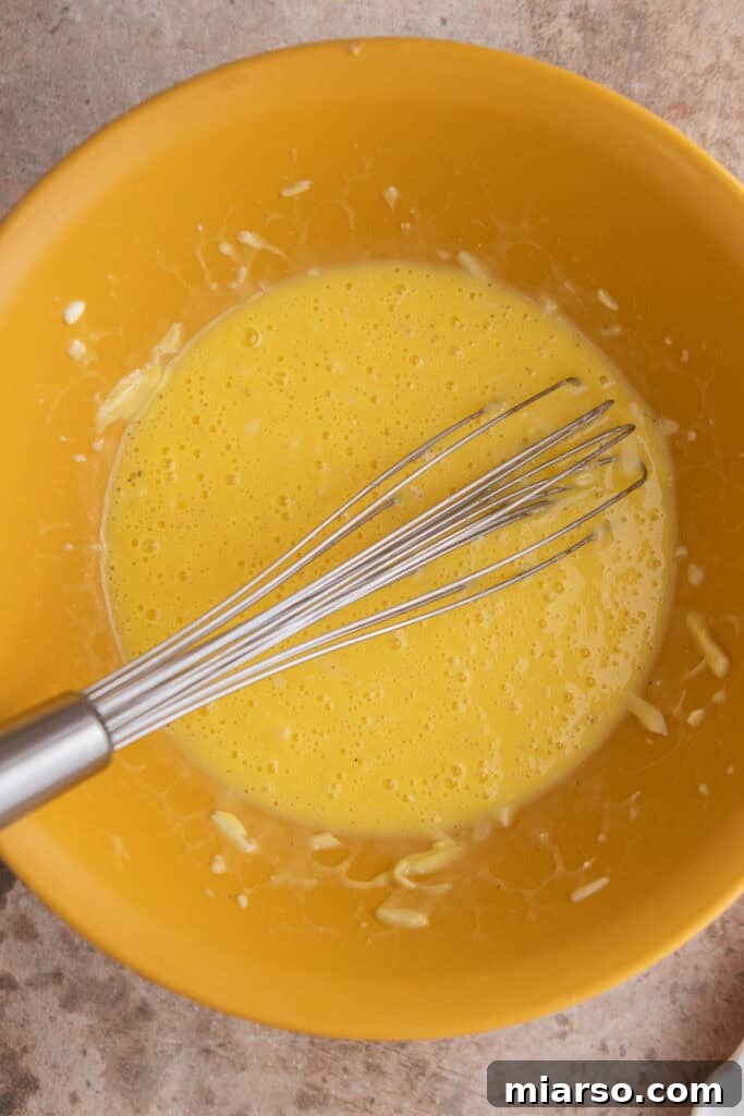 Whisked egg mixture with cheeses and seasonings, ready to be cooked into frittata patties for the Starbucks sandwich.