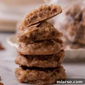 Stack of New Orleans Pralines, golden-brown and studded with pecans, showcasing the creamy texture and traditional patty shape.