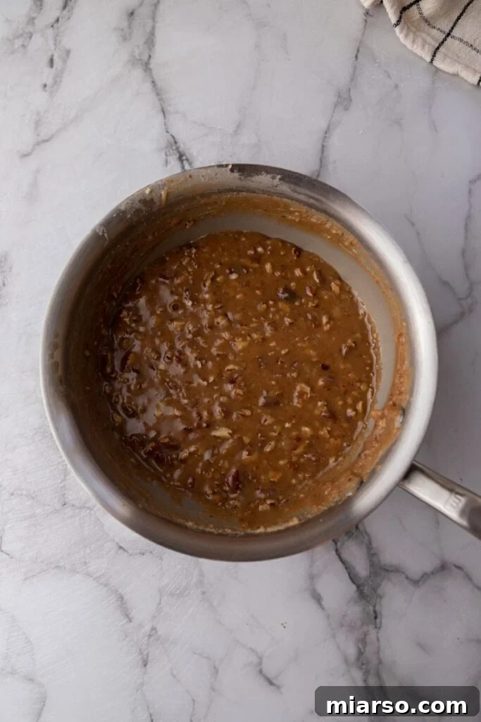 Fully cooked praline mixture, thick and creamy, ready to be scooped onto a baking sheet.