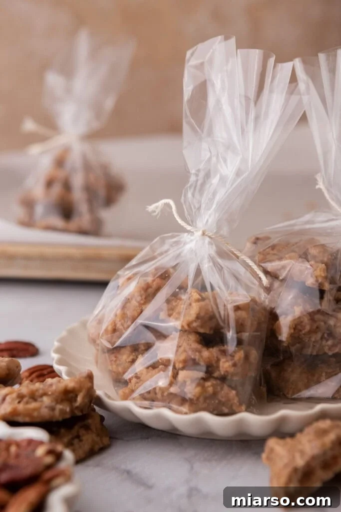A stack of finished New Orleans Pralines, individually wrapped in clear cellophane bags, ideal for gifting or sharing.
