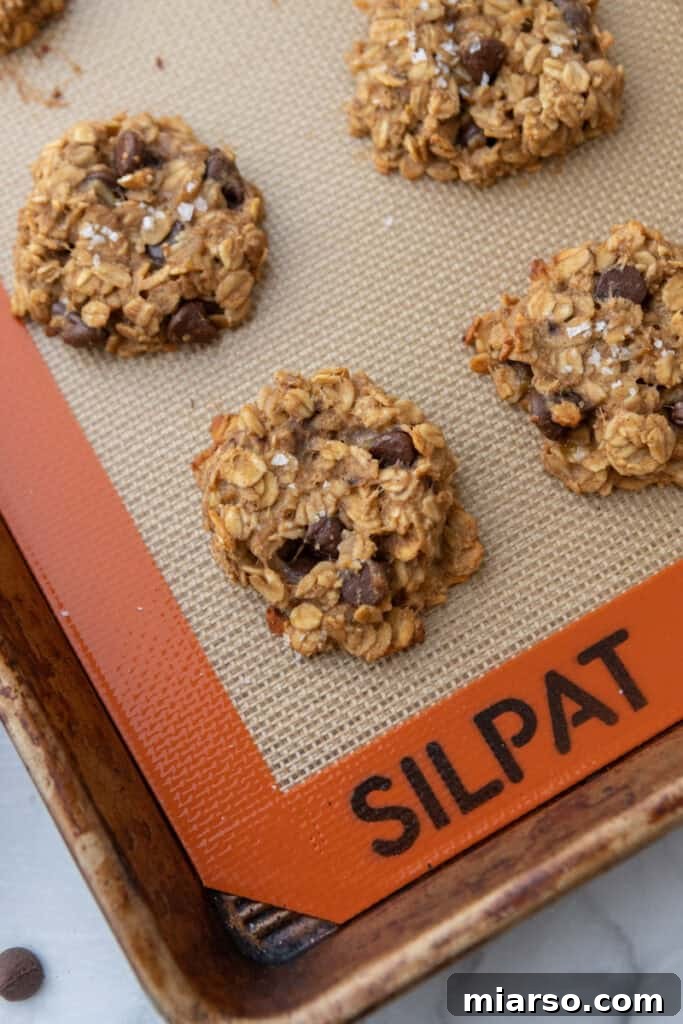 Wholesome Banana Oat Cookies 10 Fully baked oatmeal banana cookies cooling on a baking sheet