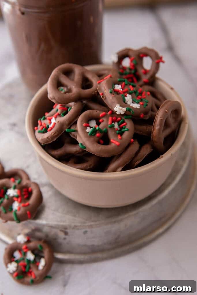 Sweet and Salty Chocolate Pretzel Delight 12 A vibrant bowl of chocolate-covered pretzels generously adorned with a variety of colorful sprinkles.