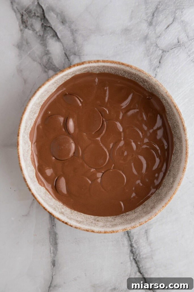 Sweet and Salty Chocolate Pretzel Delight 5 Melting chocolate in a bowl, ready for dipping pretzels.