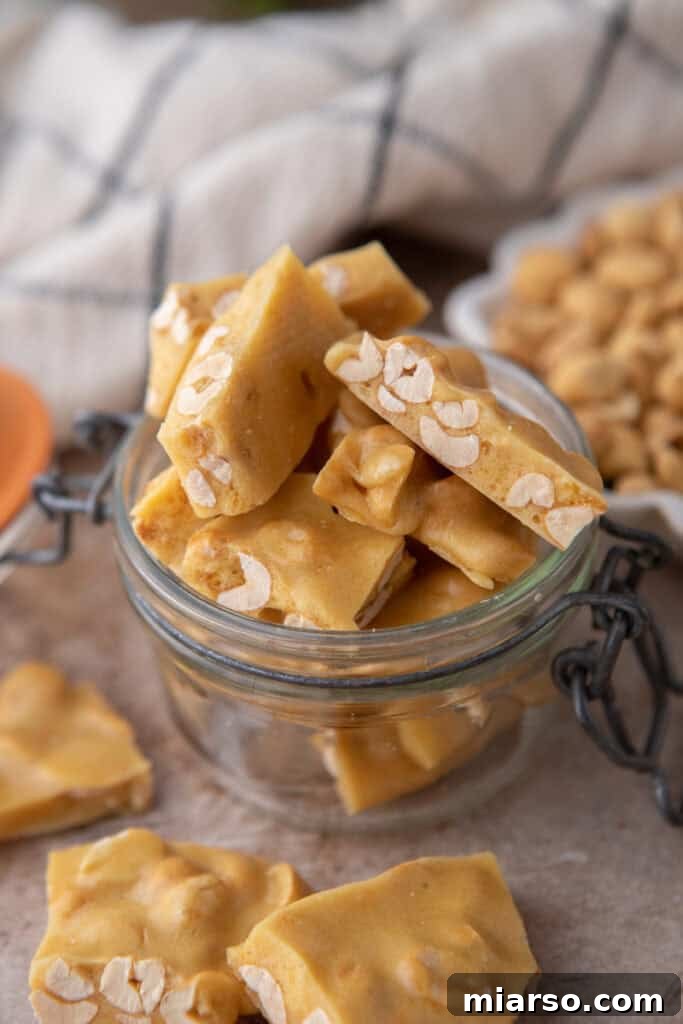 Microwave peanut brittle pieces neatly stored in a glass jar.
