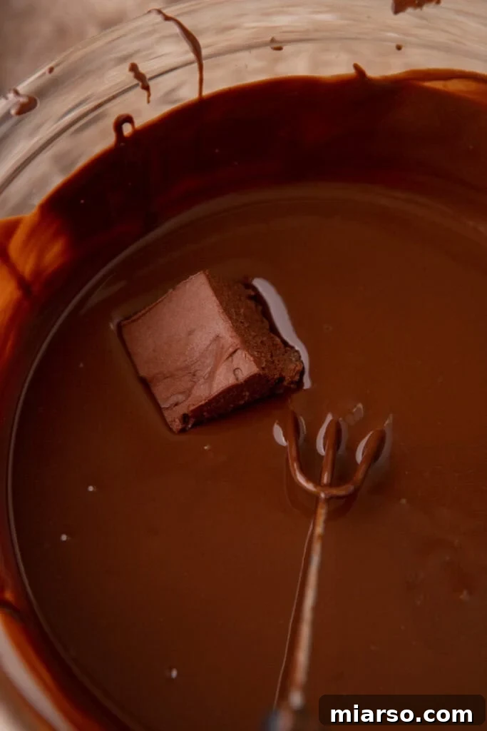 Effortless Three Musketeers Cool Whip Treats 10 A square of chilled chocolate mousse filling dipped into melted dark chocolate using a candy fork.