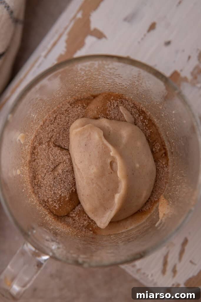 Layering snickerdoodle mug cake batter and cinnamon sugar in a cup