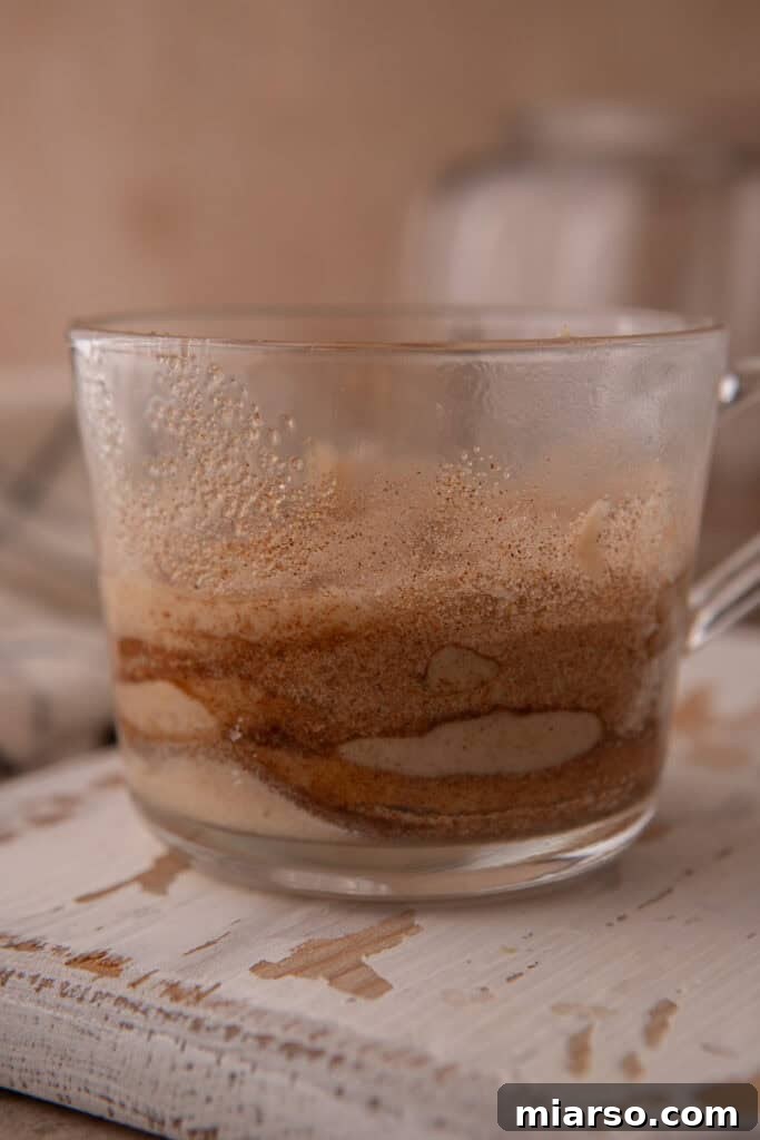 More batter layered in a cup for snickerdoodle mug cake