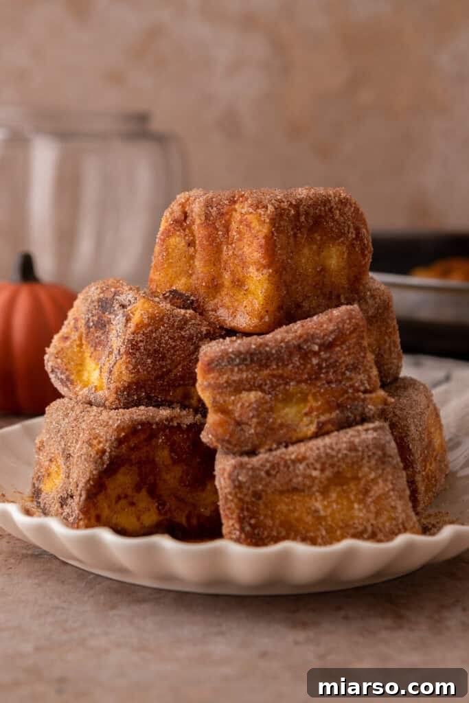 Delicious Hawaiian Roll Pumpkin French Toast squares arranged beautifully on a white plate, ready to be served for breakfast or brunch.