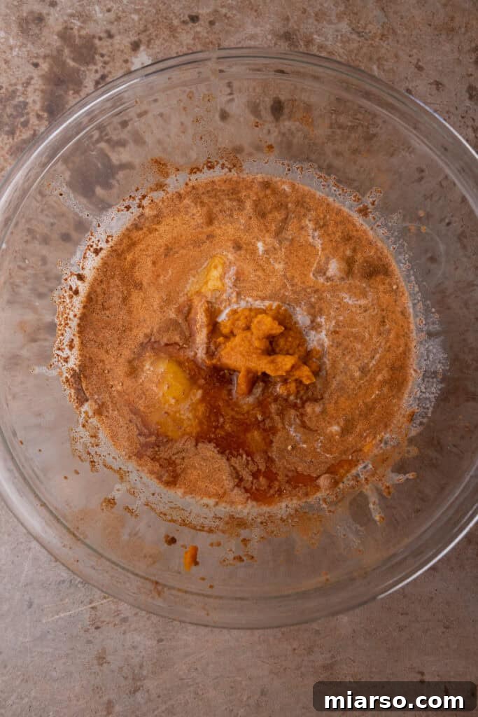 Unmixed ingredients for pumpkin French toast in a glass bowl.