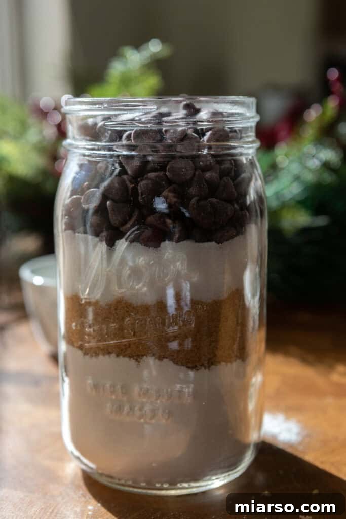 Topping the cookie mix jar with chocolate chips