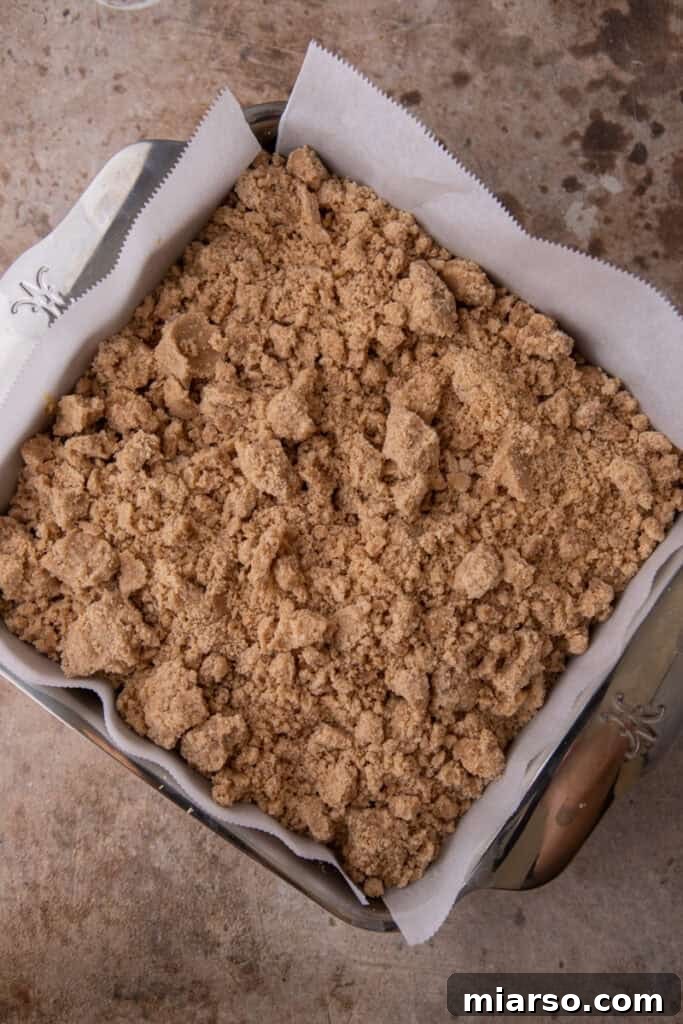 Close-up of the streusel topping perfectly covering the pumpkin cake batter, ready for baking.