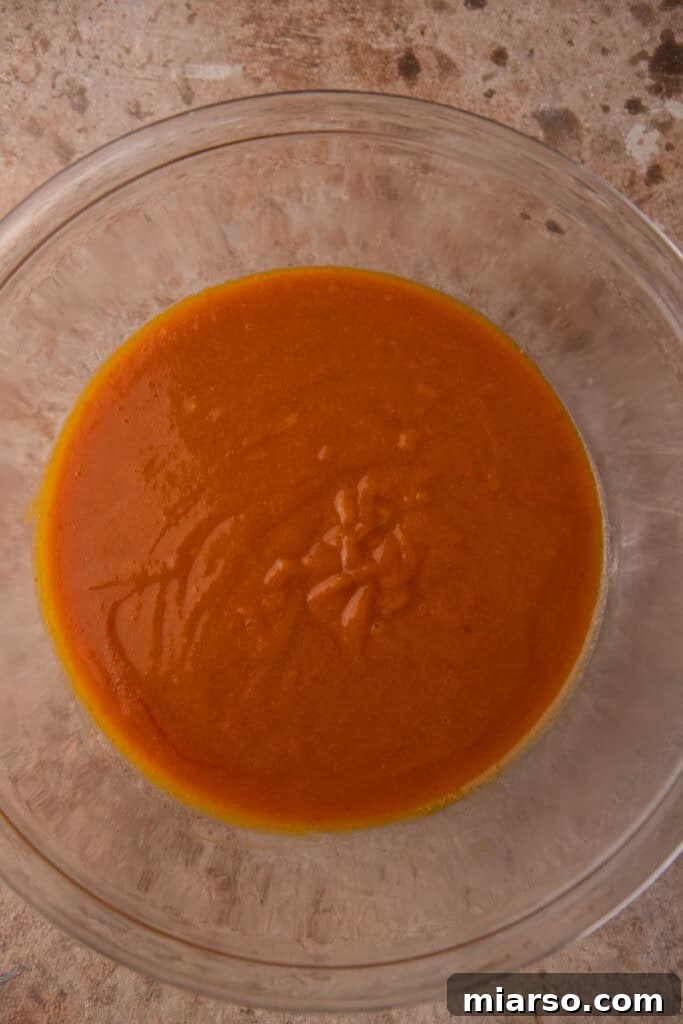 Wet and dry ingredients for the pumpkin coffee cake batter being gently folded together.
