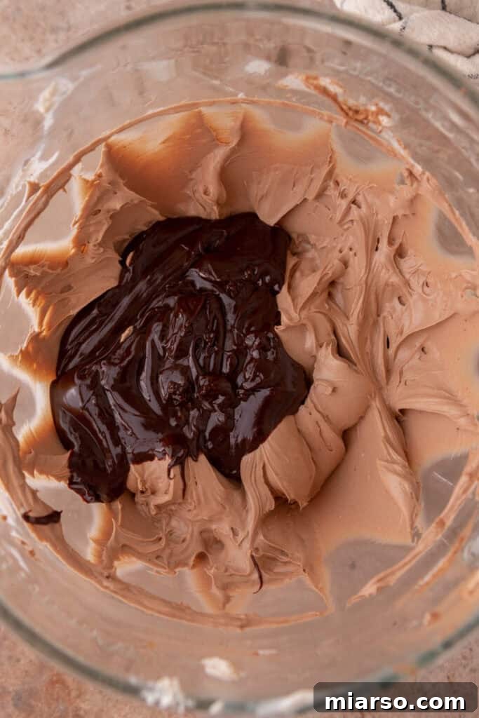 Sifted cocoa powder and vanilla extract added to the cream cheese mixture.