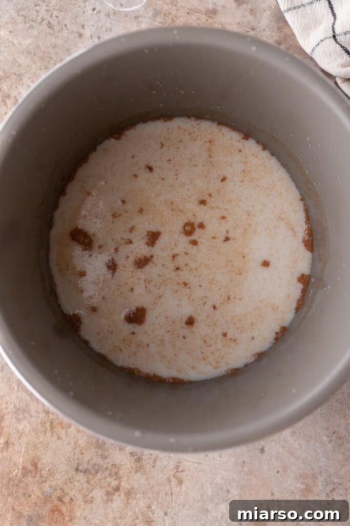 Uncooked steel cut oats and liquids mixed in the Instant Pot liner, ready for pressure cooking.