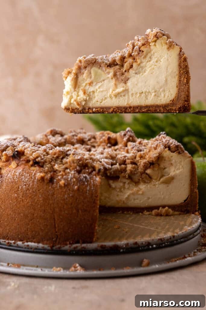 apple crisp cheesecake recipe with a slice being held up