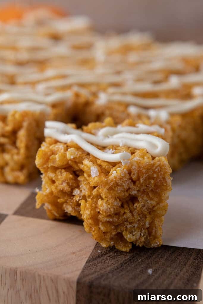 Close-up of a pumpkin rice krispie treat showing its crispy and chewy texture with a hint of spice.