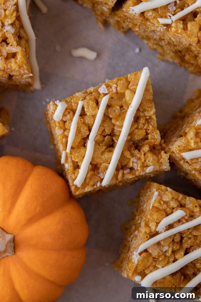 Overhead shot of pumpkin rice krispie treats arranged artfully on a cooling rack, ready for slicing.