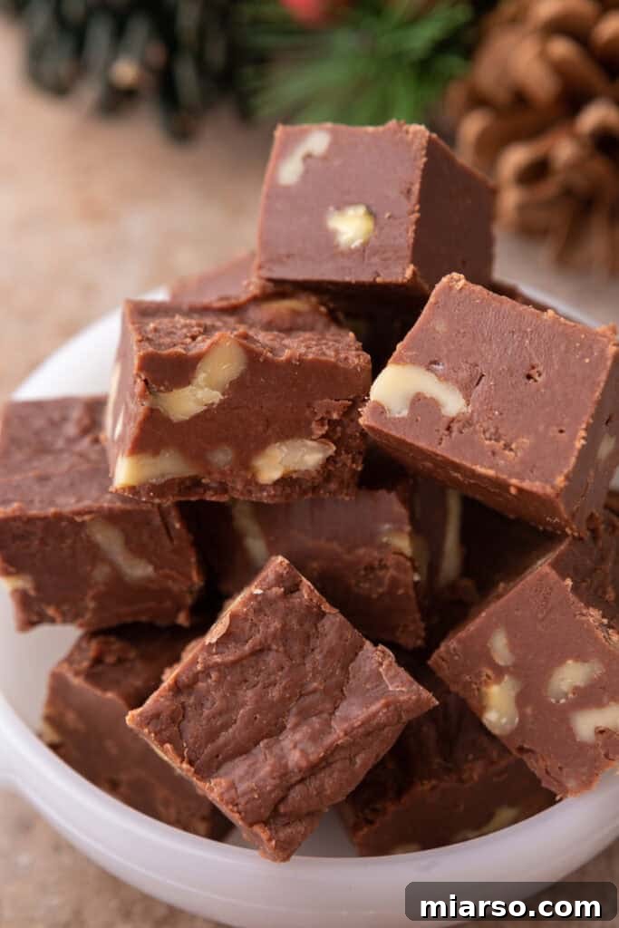 see's candy fudge recipe pieces stacked in a bowl, showcasing its rich, dark chocolate color and smooth texture