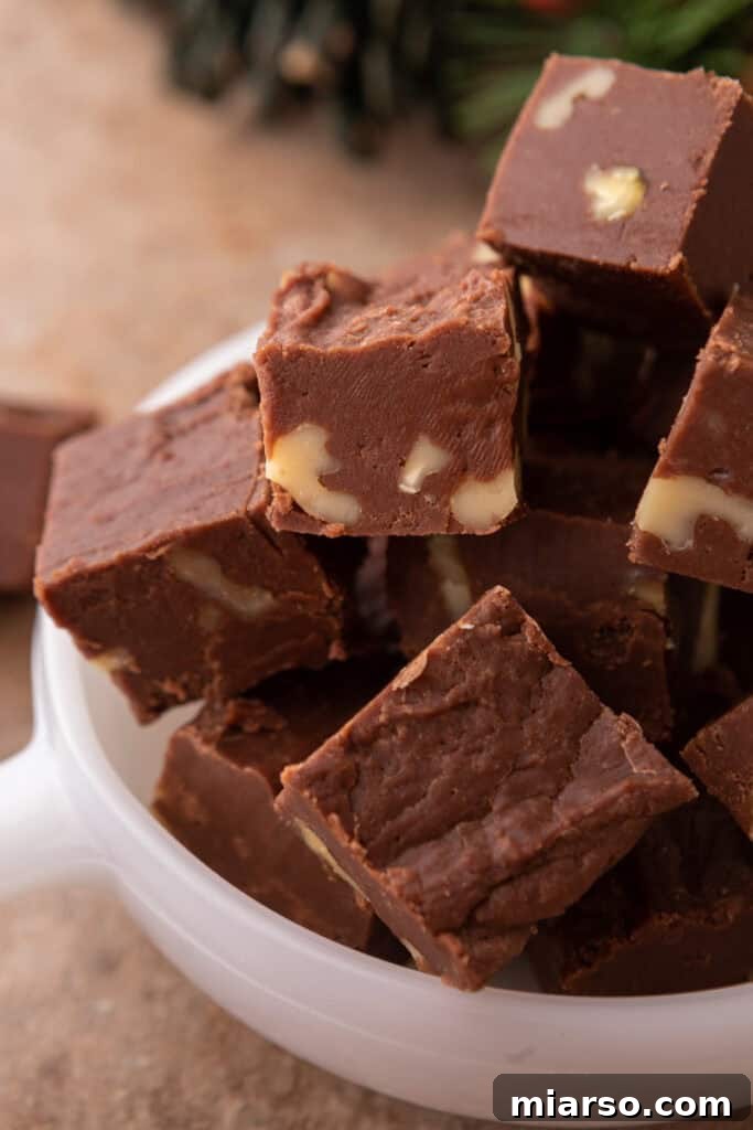 close up of see's candy fudge recipe, showing its smooth, glossy surface and embedded walnuts