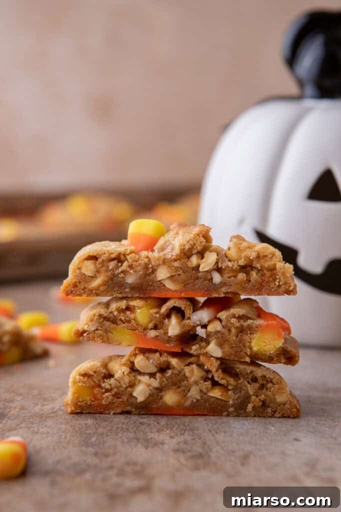 A side shot of a perfectly baked candy corn cookie, showing its thick, chewy texture and visible candy corn pieces.