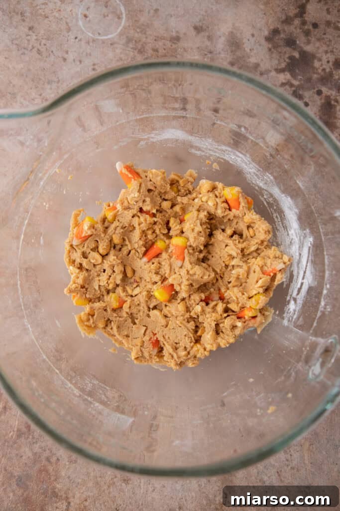 Cookie dough with peanuts and candy corn folded in, ready for chilling.