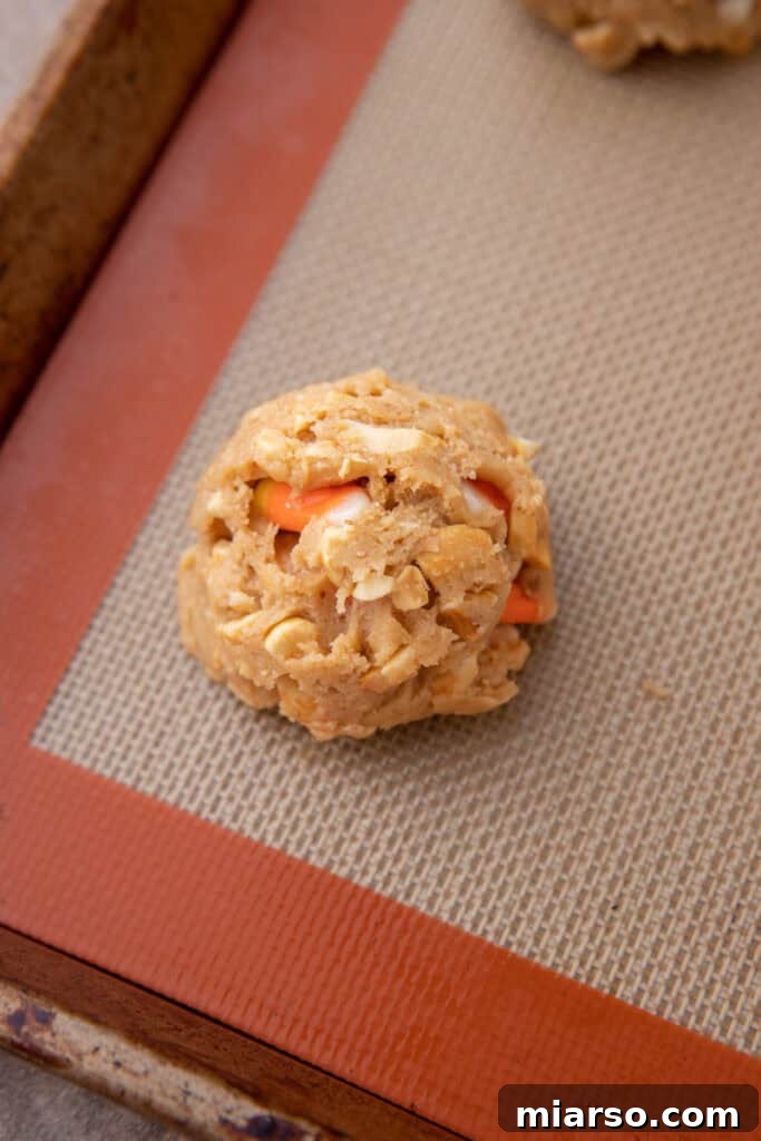 Scooped cookie dough balls arranged on a parchment-lined baking sheet.