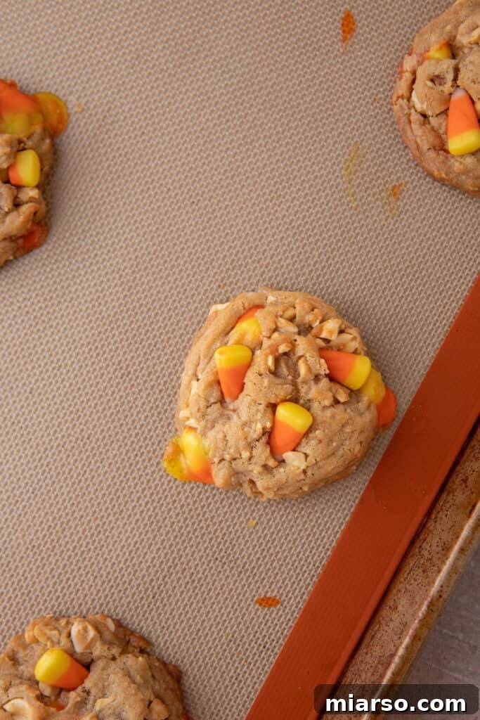 Freshly baked candy corn cookies cooling on a baking sheet.