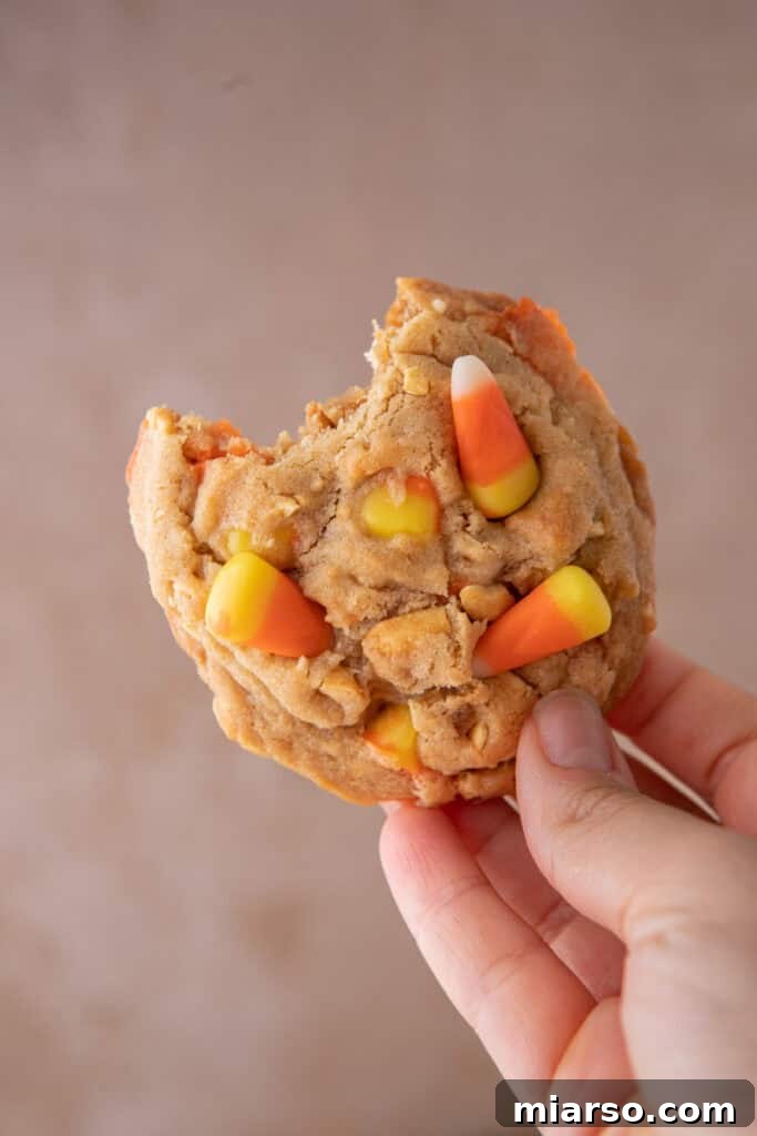Another shot of a candy corn cookie being held, highlighting its festive appearance.