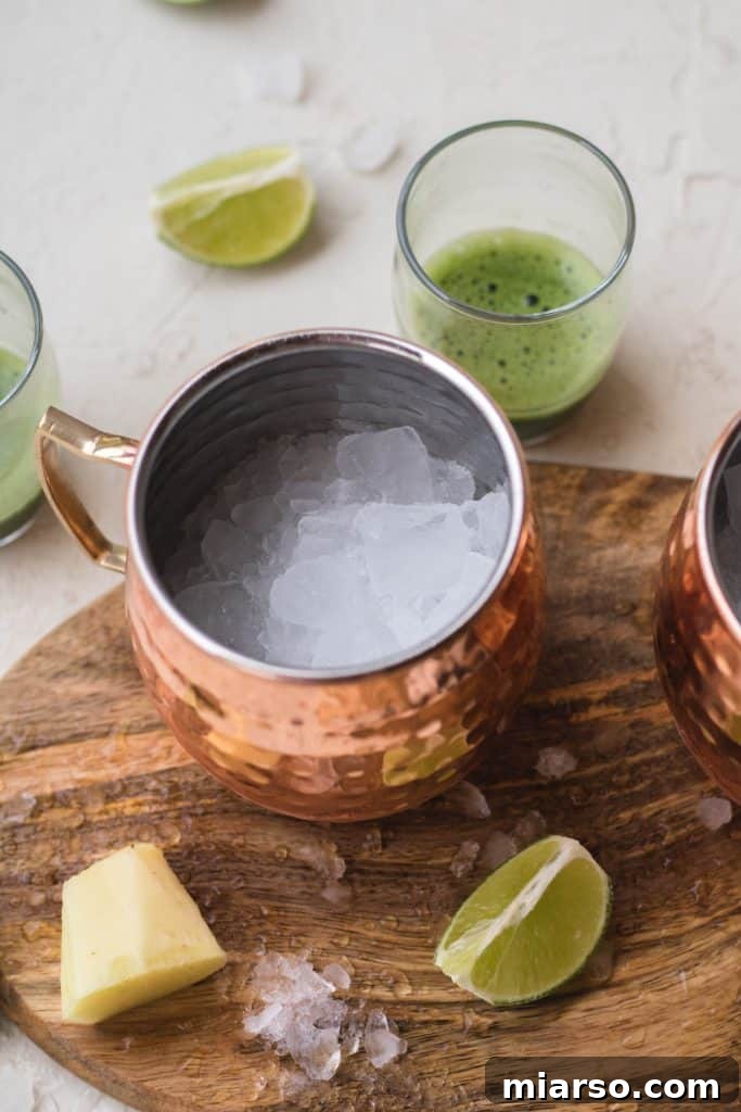 Squeezing fresh lime into a copper mug filled with ice