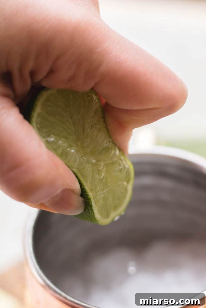 Filling copper mugs with ginger ale and lime