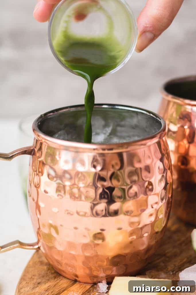 Pouring matcha into a Moscow Mule mug with ice