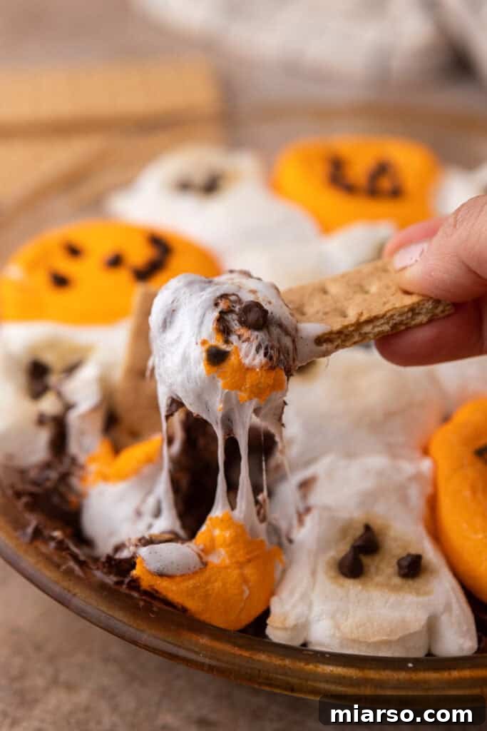 Bewitching Halloween S'mores Dip 2 Halloween S'mores Dip Recipe getting scooped up