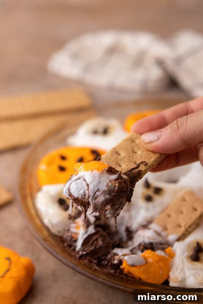 Bewitching Halloween S'mores Dip 10 Halloween S'mores Dip Recipe getting scooped up