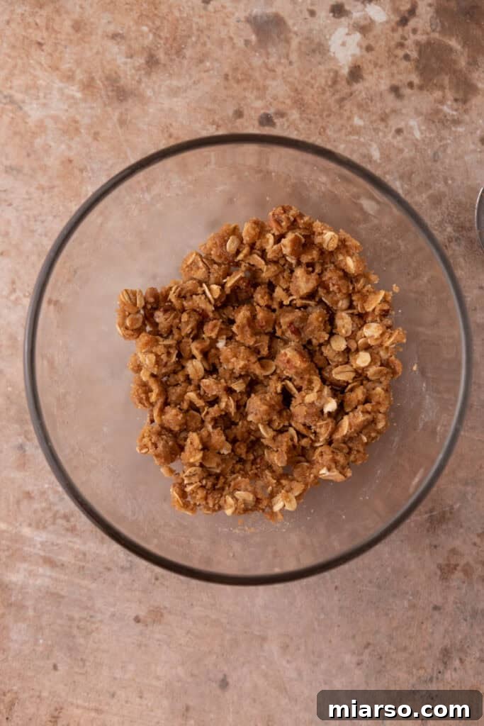 Crisp topping ingredients mixed with melted butter, forming a crumbly texture.