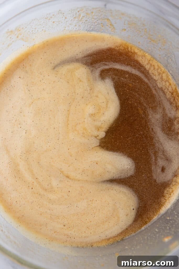 The combined egg and maple-butter mixture in a bowl, showcasing a smooth, cohesive, and rich amber-colored filling ready to be poured into the pie crust.