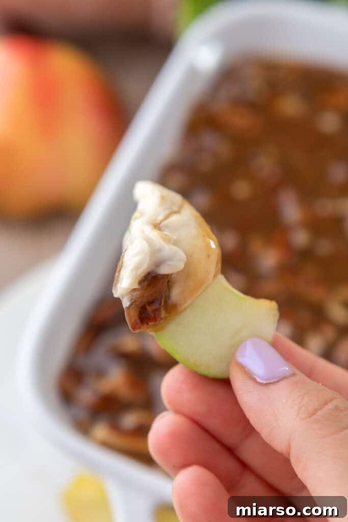 Irresistible Pecan Pie Dip 12 A crisp apple slice topped with Pecan Pie Dip, ready for a bite.