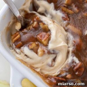 Pecan Pie Dip being scooped from a serving dish, highlighting its luscious texture.
