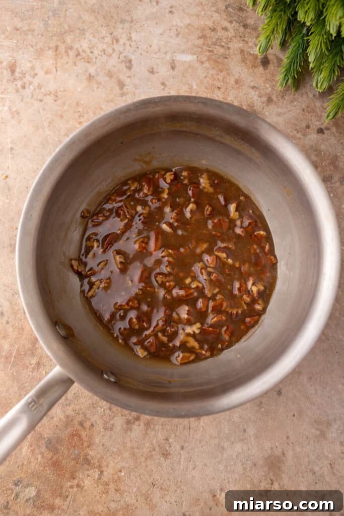 Irresistible Pecan Pie Dip 6 Mixed and cooked pecan pie layer ingredients in a saucepan, showing the gooey texture.
