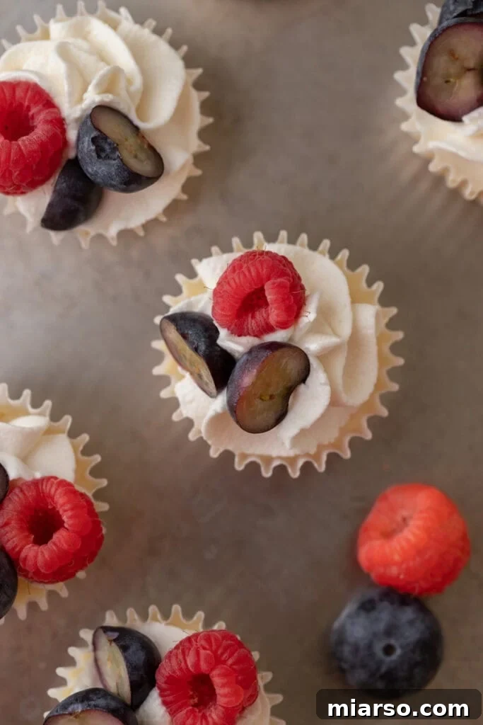 Nilla Wafer Mini Cheesecake Perfection 12 An overhead shot of several mini cheesecakes with Nilla wafers, some plain and some topped with fruit, on a rustic wooden surface.