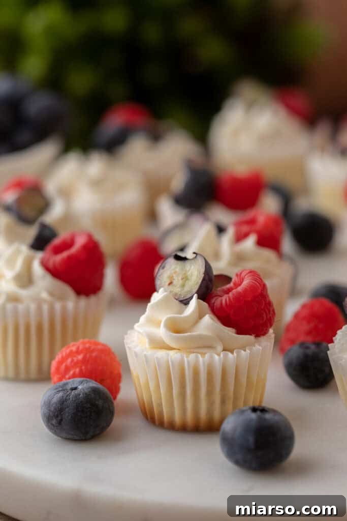Nilla Wafer Mini Cheesecake Perfection 14 A plate of mini cheesecakes with Nilla wafer crusts, some topped with fresh berries, showcasing their elegant presentation.