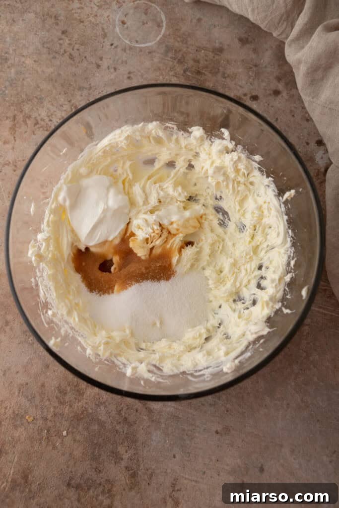 Nilla Wafer Mini Cheesecake Perfection 5 Unmixed cream cheese, sugar, sour cream, and vanilla extract in a bowl, before beating.