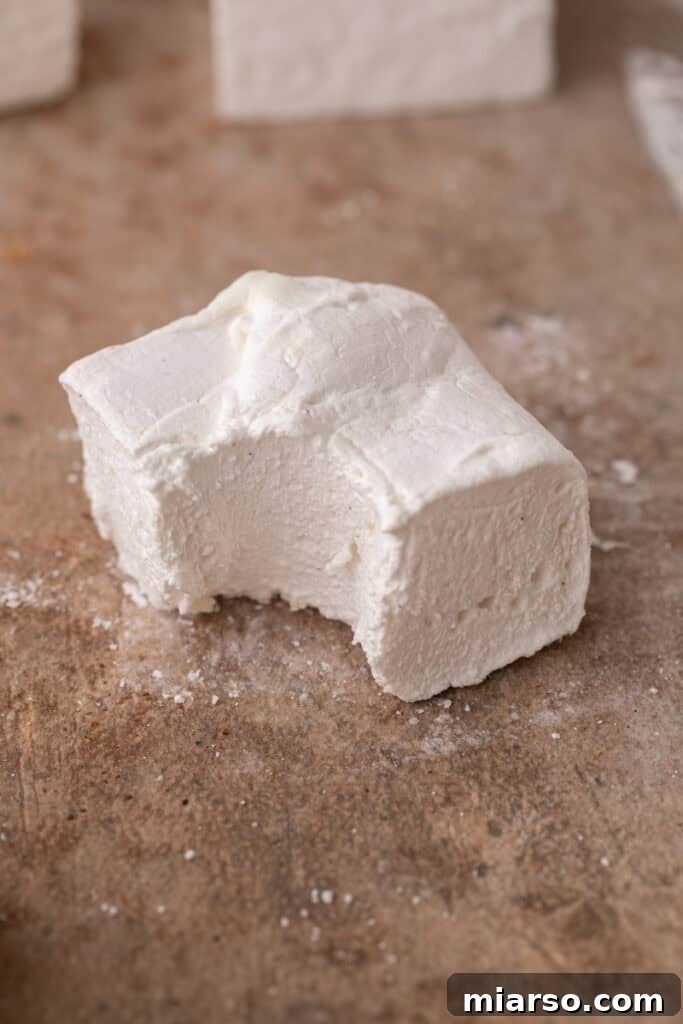 a single homemade marshmallow with a bite taken out, showing its fluffy interior