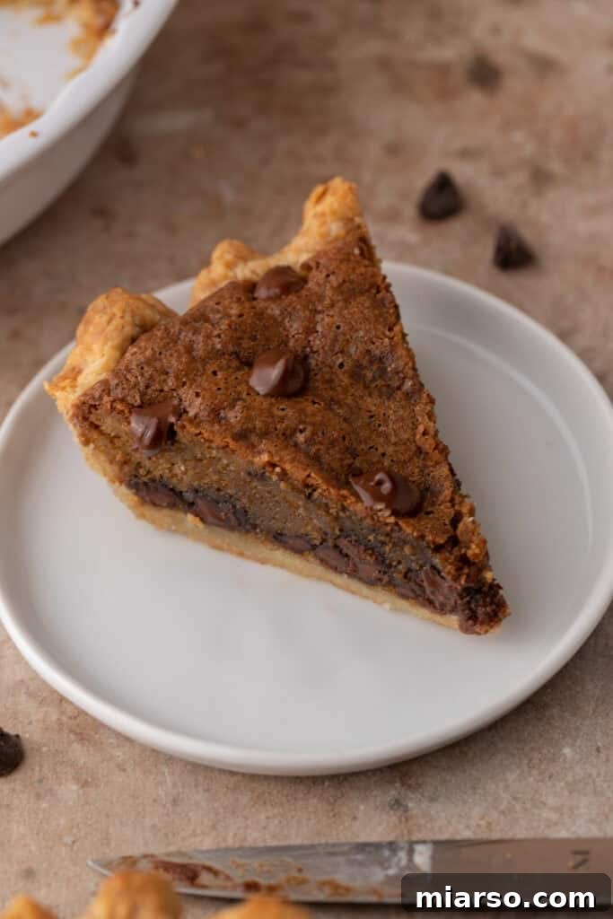 a sliced chocolate chip cookie pie on a wire rack, revealing its soft texture and chocolate distribution